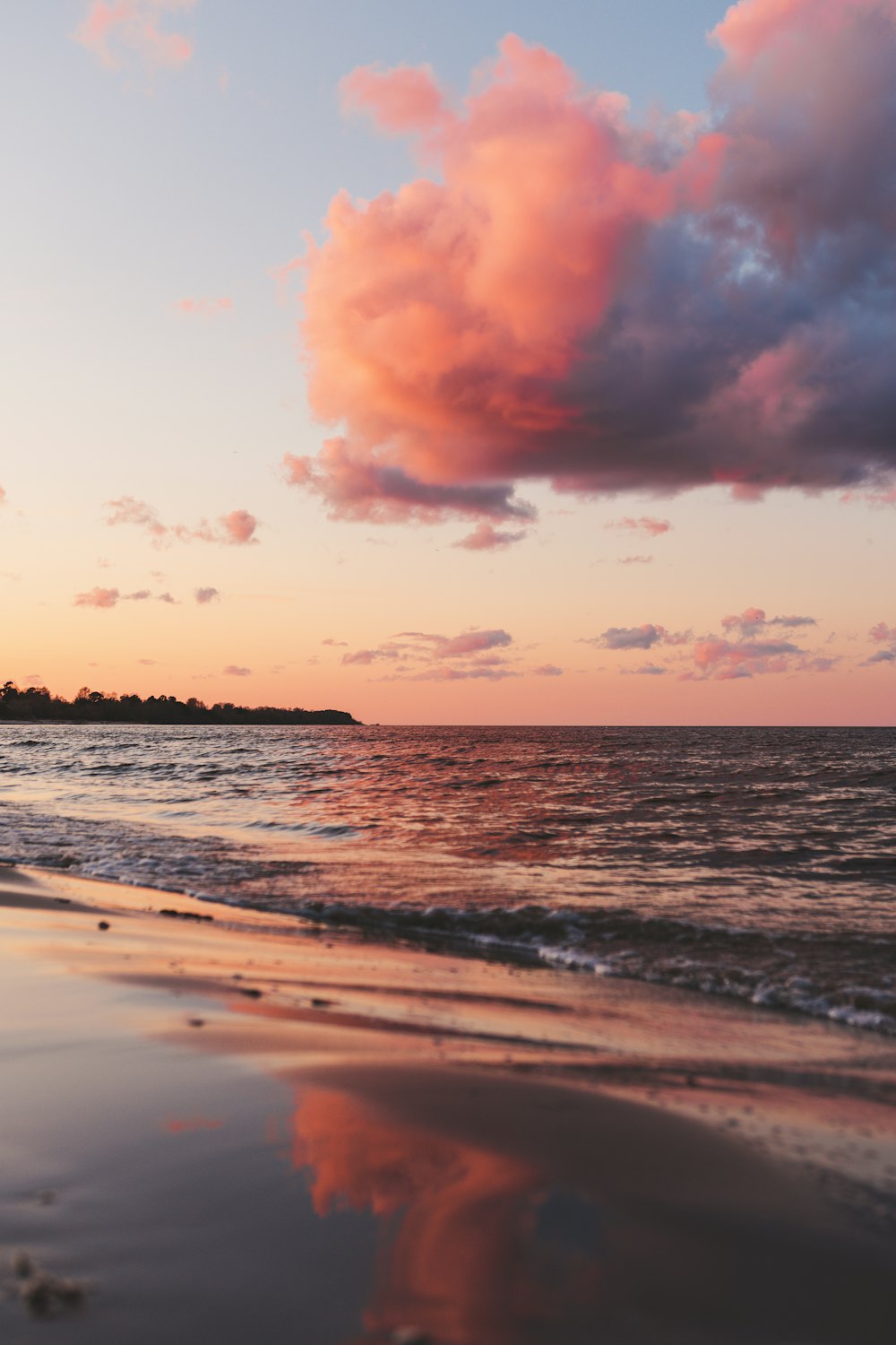 sea waves crashing on shore during sunset