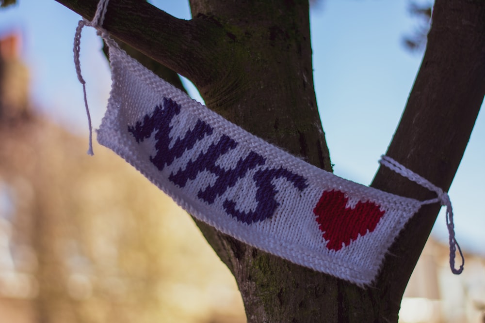 white and red knit textile on brown tree branch