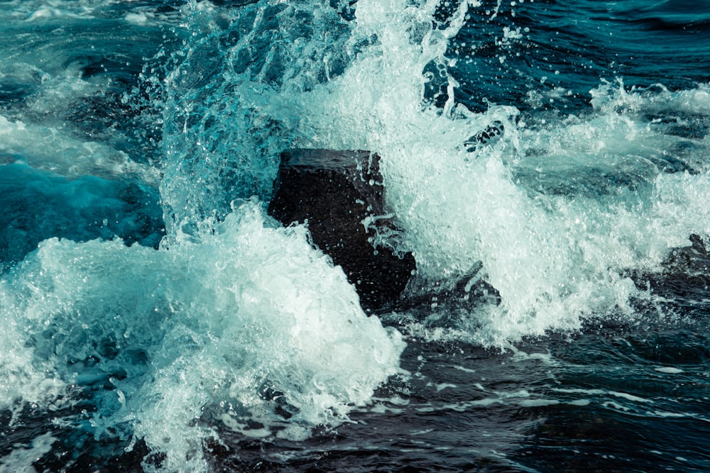 water waves hitting rocks during daytime