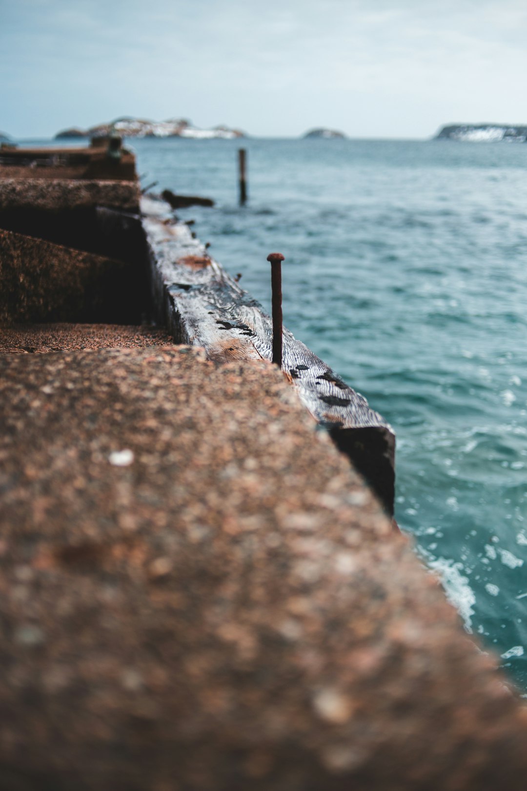 brown concrete dock near body of water during daytime