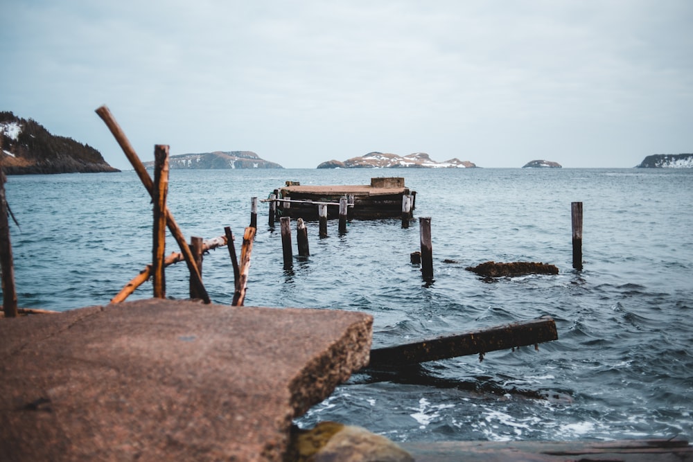 Muelle de madera marrón en el mar durante el día