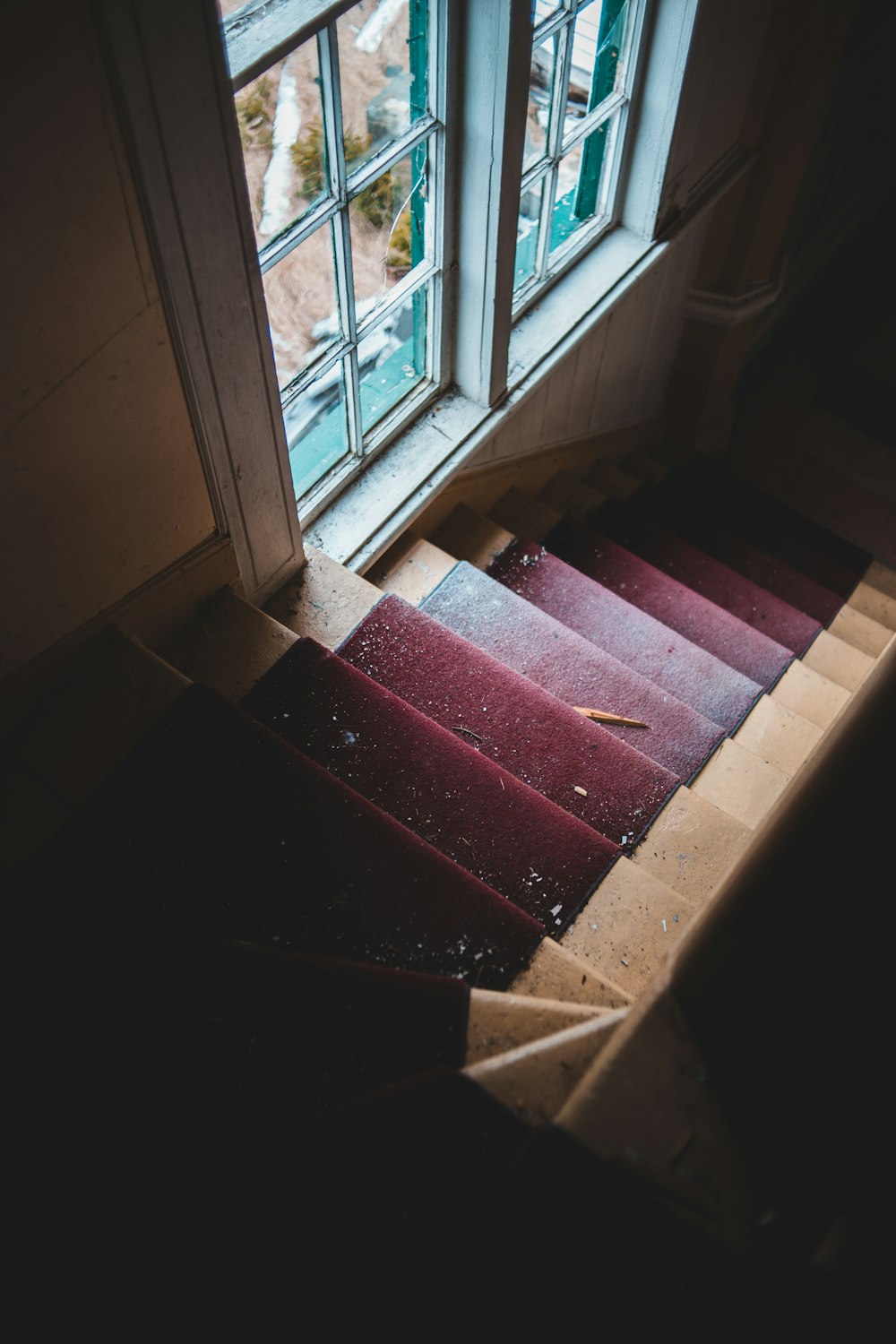 red and brown staircase near white framed glass window
