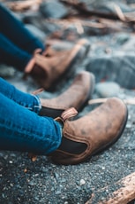 person in blue denim jeans and brown leather shoes