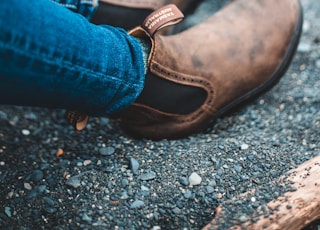 person in blue denim jeans and brown leather shoes