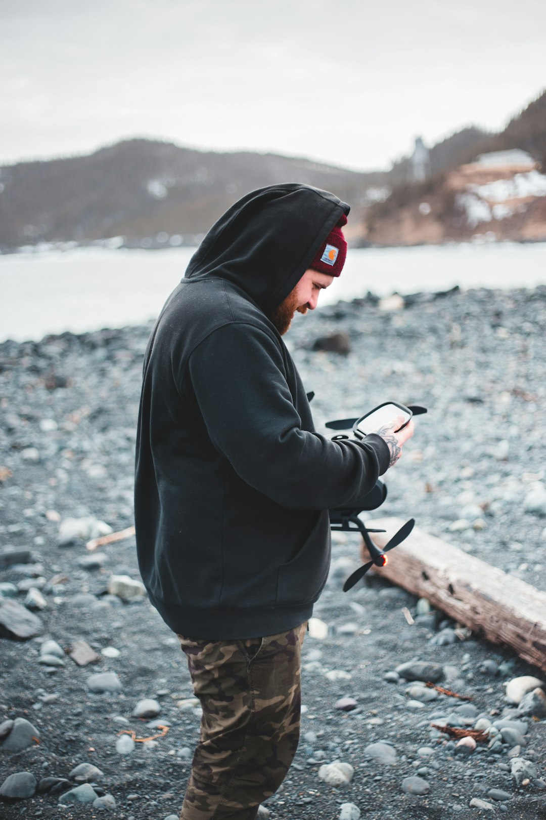 man in black hoodie and brown shorts holding black dslr camera