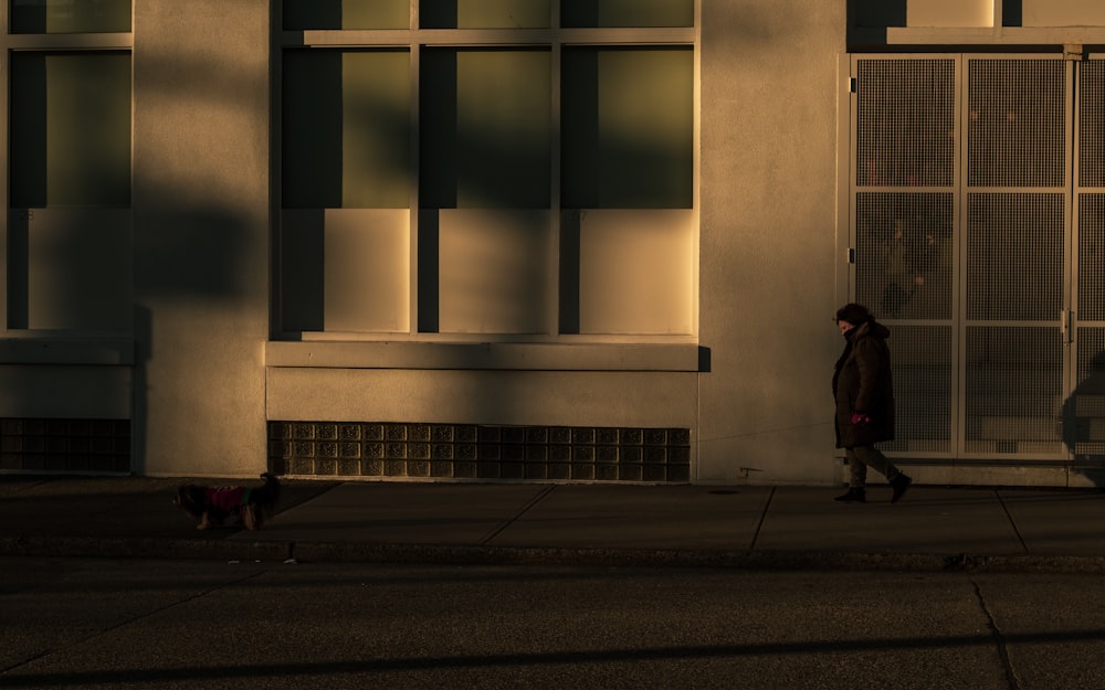 person in black jacket walking on sidewalk during daytime