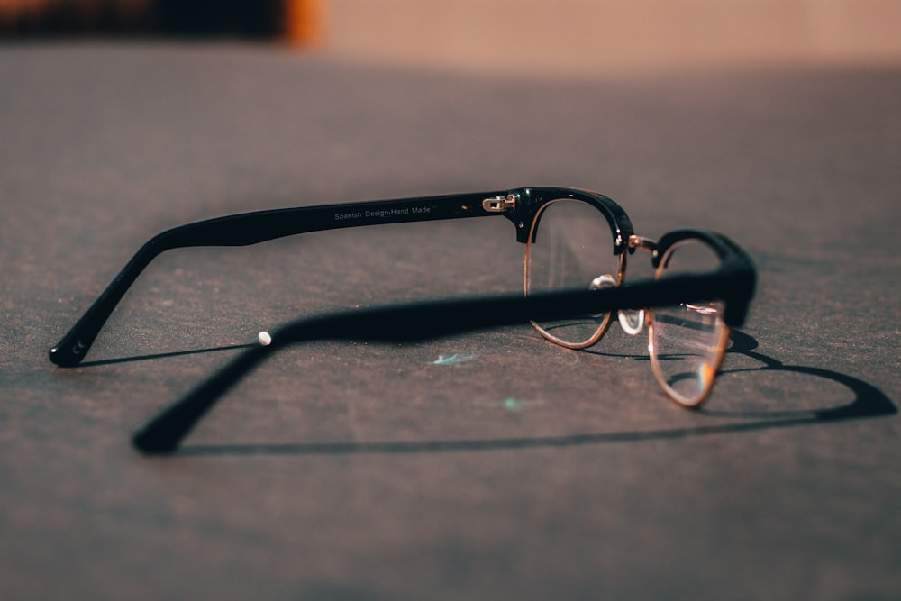 black framed eyeglasses on gray surface