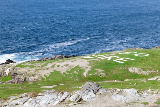 green grass field near body of water during daytime in Malin Head Signal Station Ireland