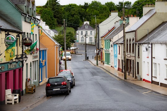 black suv parked beside blue green and yellow houses during daytime in Ardara Ireland