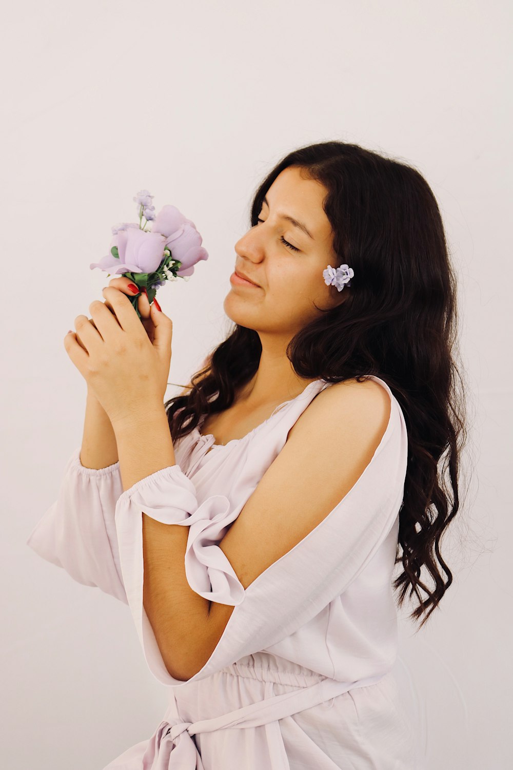 woman in white sleeveless dress holding white rose