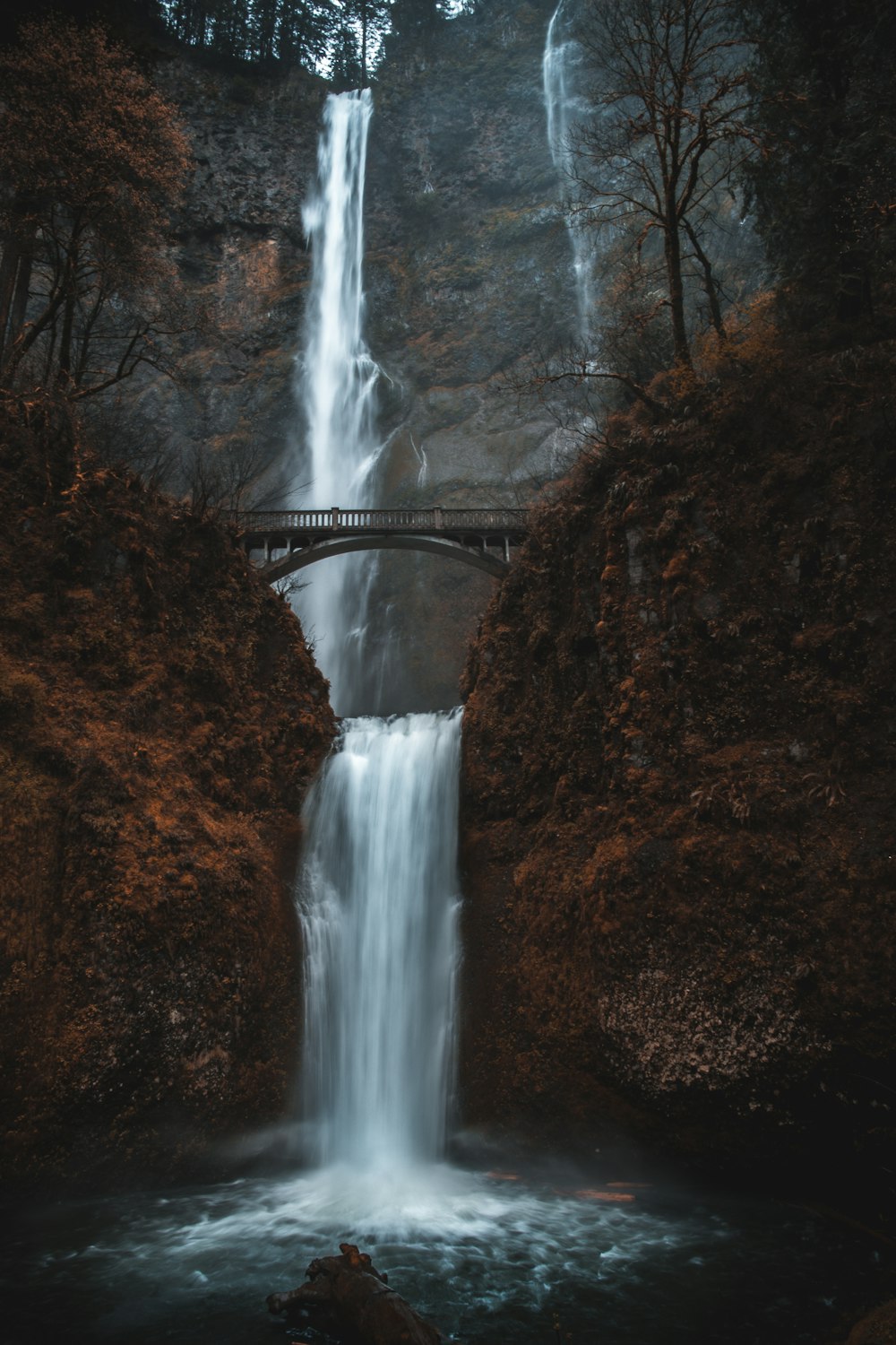 waterfalls under bridge during daytime