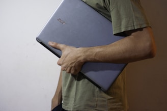 man in green button up shirt holding black tablet computer