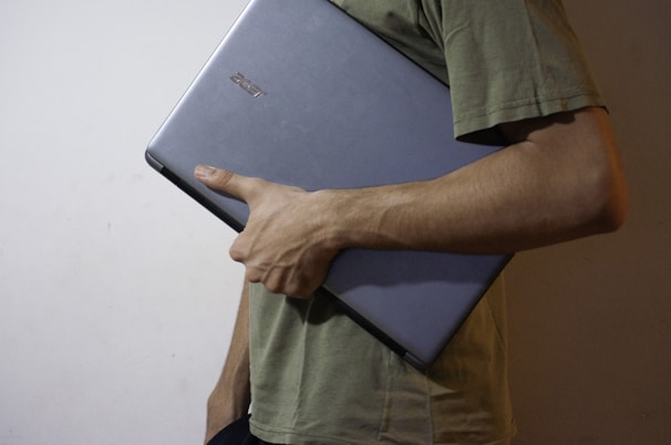 man in green button up shirt holding black tablet computer