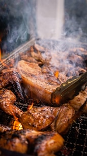 Close-up of juicy grilled chicken pieces sizzling over hot coals.