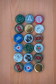 Close-up of colorful plastic bottle caps neatly arranged on a white surface.
