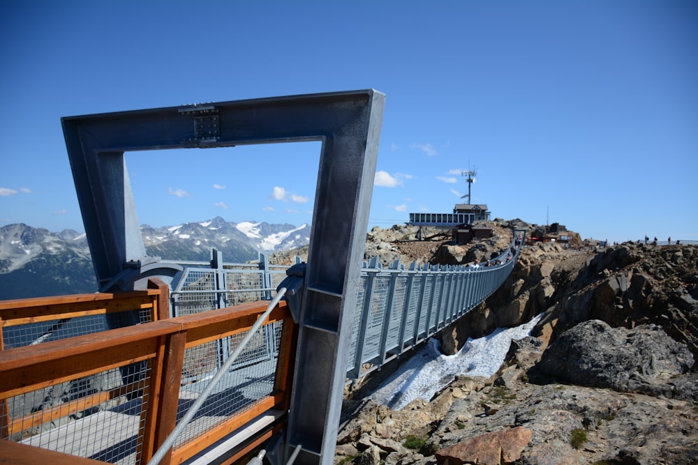 brown wooden railings on rocky mountain during daytime