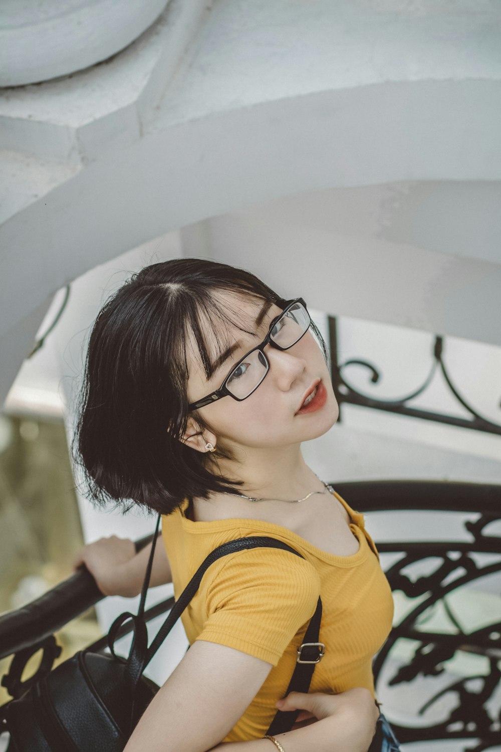 Chica con camisa amarilla con gafas de montura negra