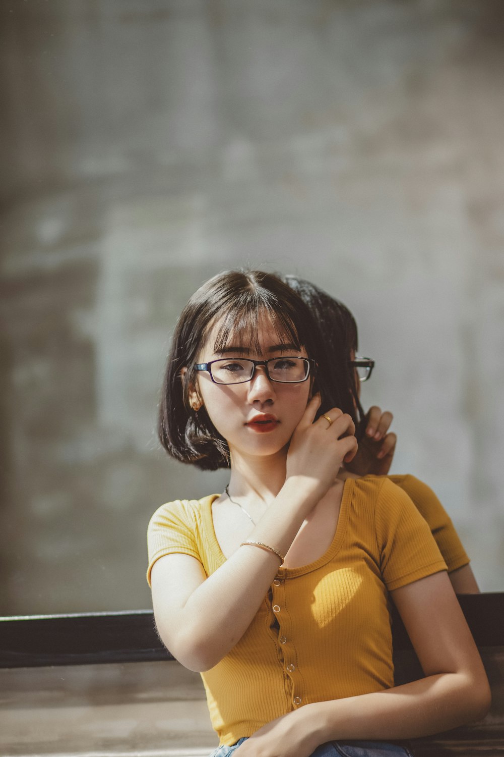 woman in yellow shirt wearing black framed eyeglasses