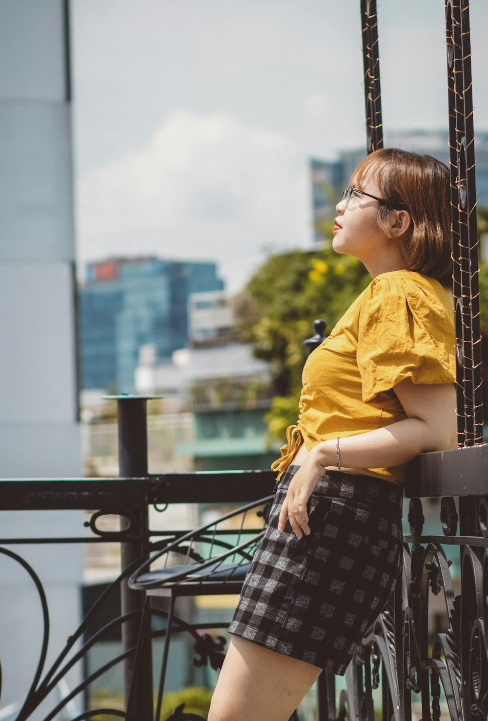 Foto chica con camisa amarilla y falda a cuadros en blanco y negro parada  en un banco de madera marrón durante – Imagen Ho chi minh gratis en Unsplash
