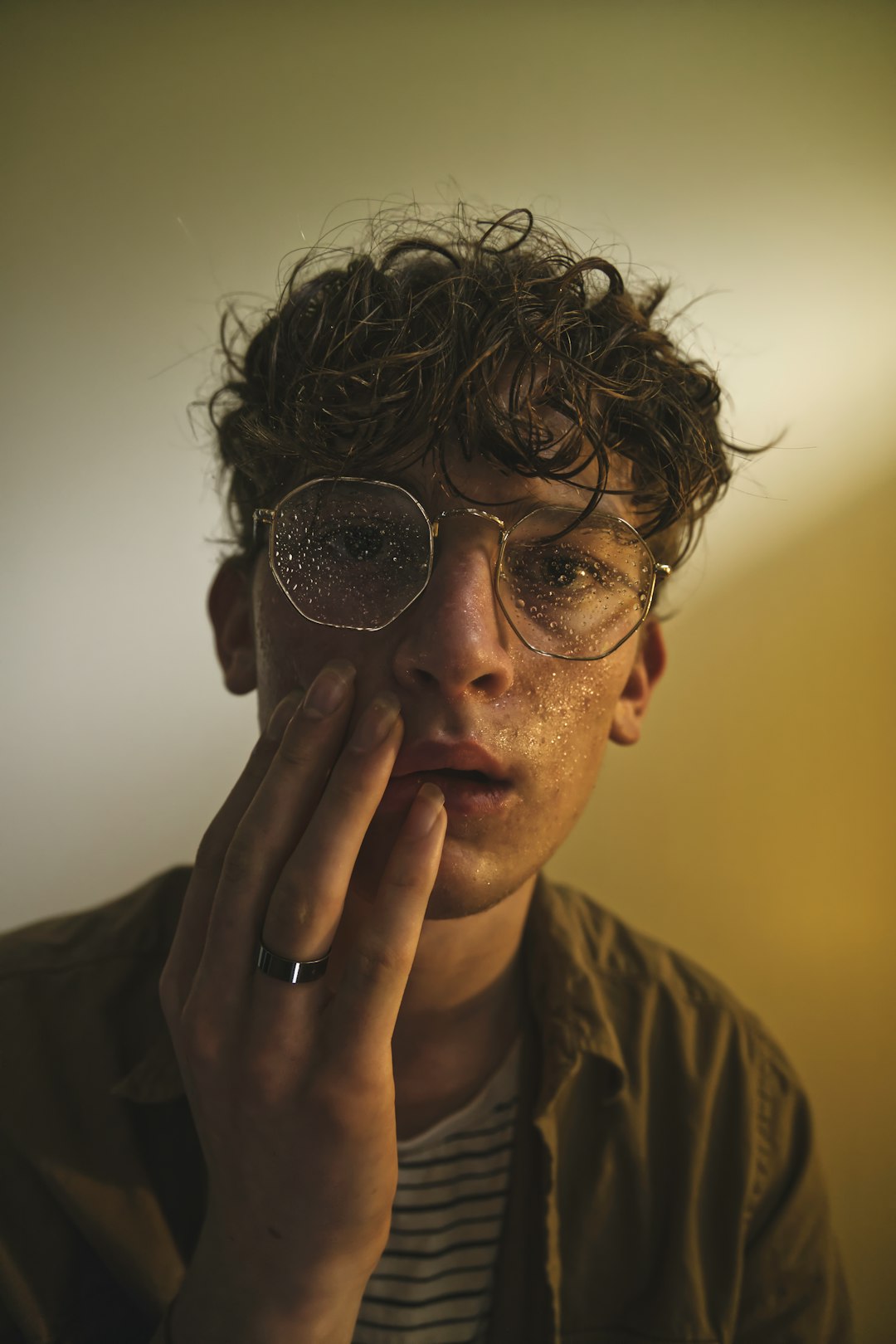 man in brown crew neck shirt wearing black framed sunglasses