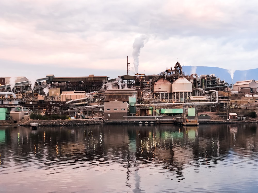 brown and white concrete building beside river under white clouds during daytime