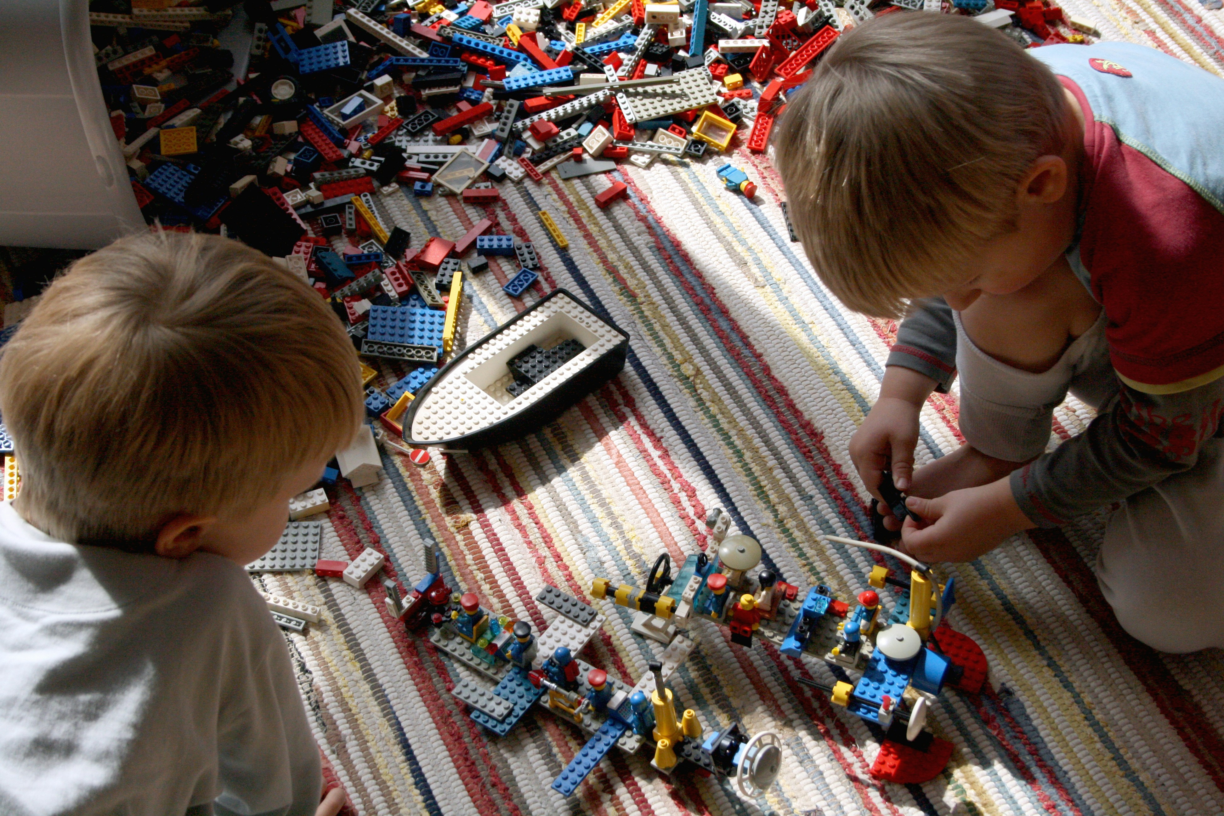 boy in white t-shirt playing lego blocks