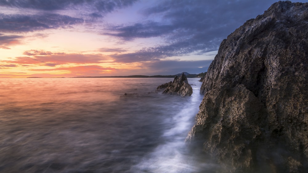 Les vagues de l’océan s’écrasant sur le rivage rocheux au coucher du soleil