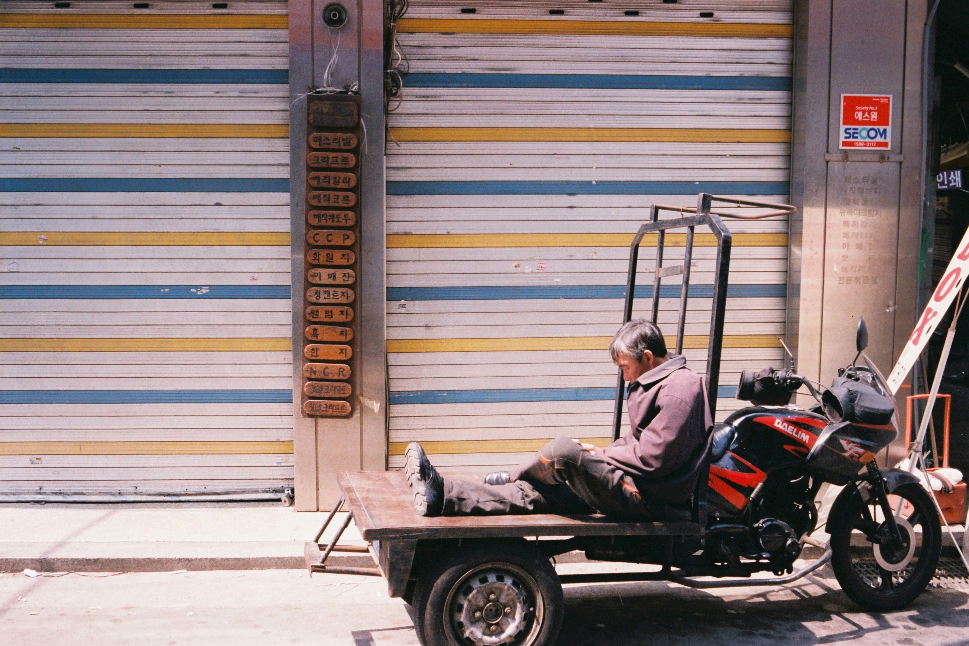 man in black jacket riding on black and red auto rickshaw
