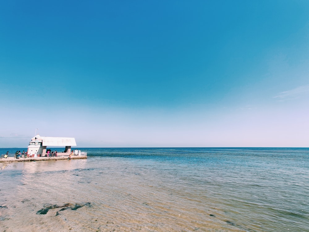 white and blue wooden house on beach during daytime