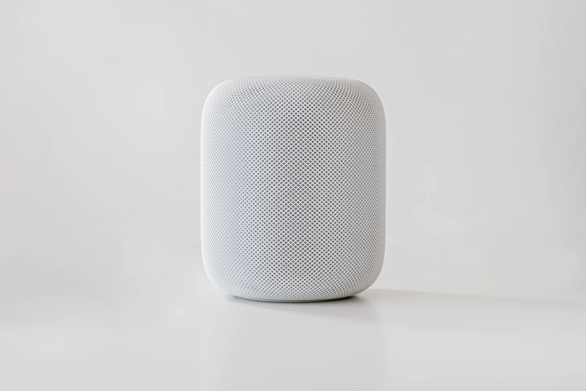 Compact white smart speaker on a pale background
