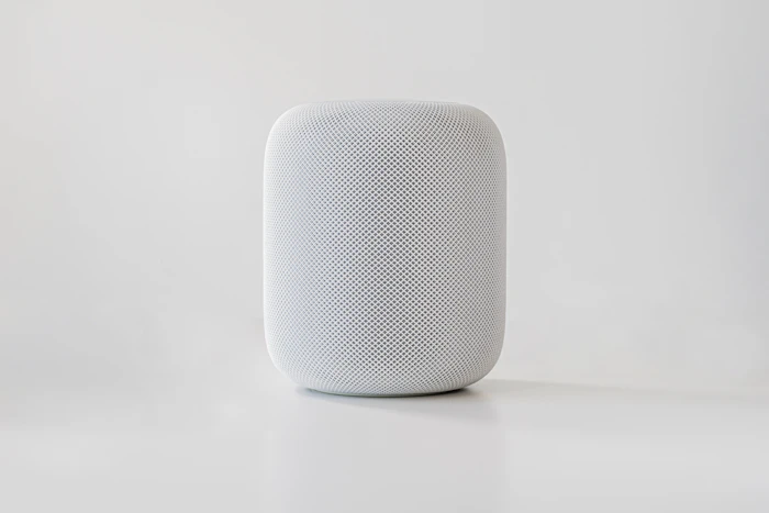 Compact white smart speaker on a pale background