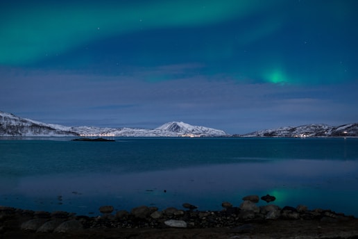 A serene Icelandic landscape under shimmering northern lights with ancient runes carved into nearby stones.