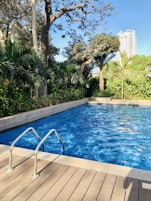 A well-maintained pool with clear blue water and surrounding greenery.