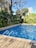 A sparkling clean swimming pool surrounded by greenery.