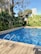 Image showing a sparkling clean swimming pool surrounded by lush greenery.