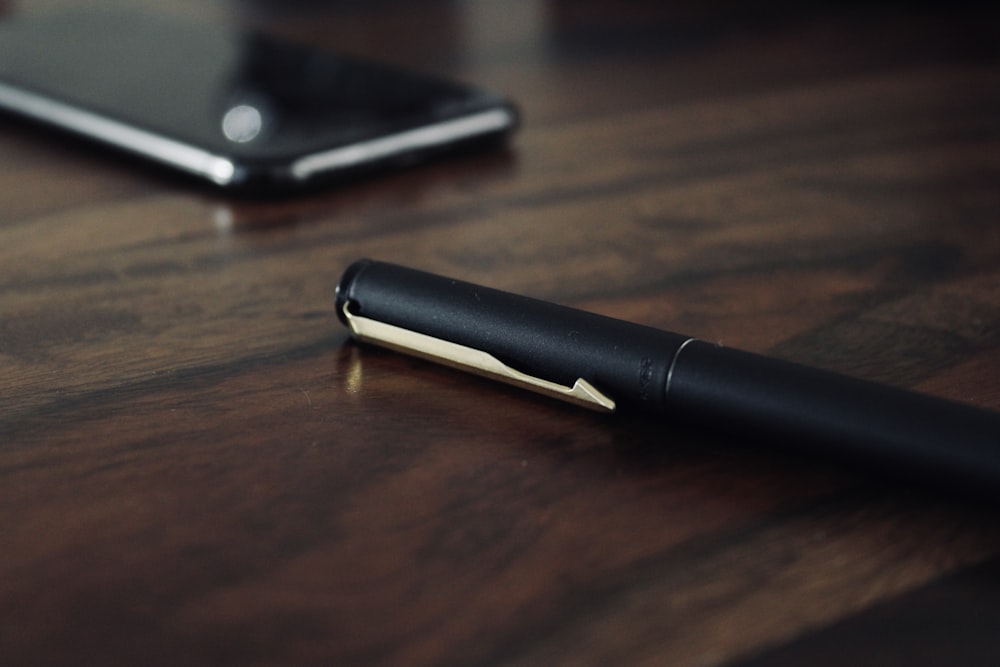 black smartphone on brown wooden table