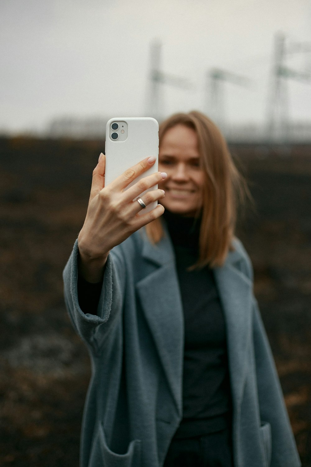 woman in gray long sleeve shirt holding white smartphone