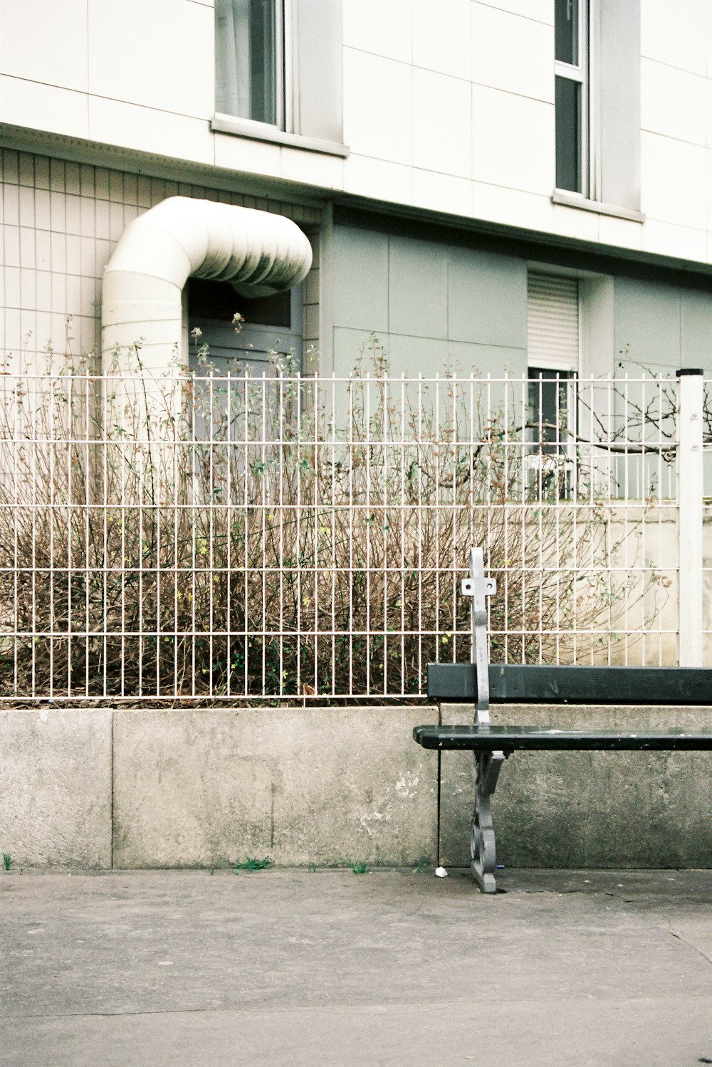 black metal bench beside white wall