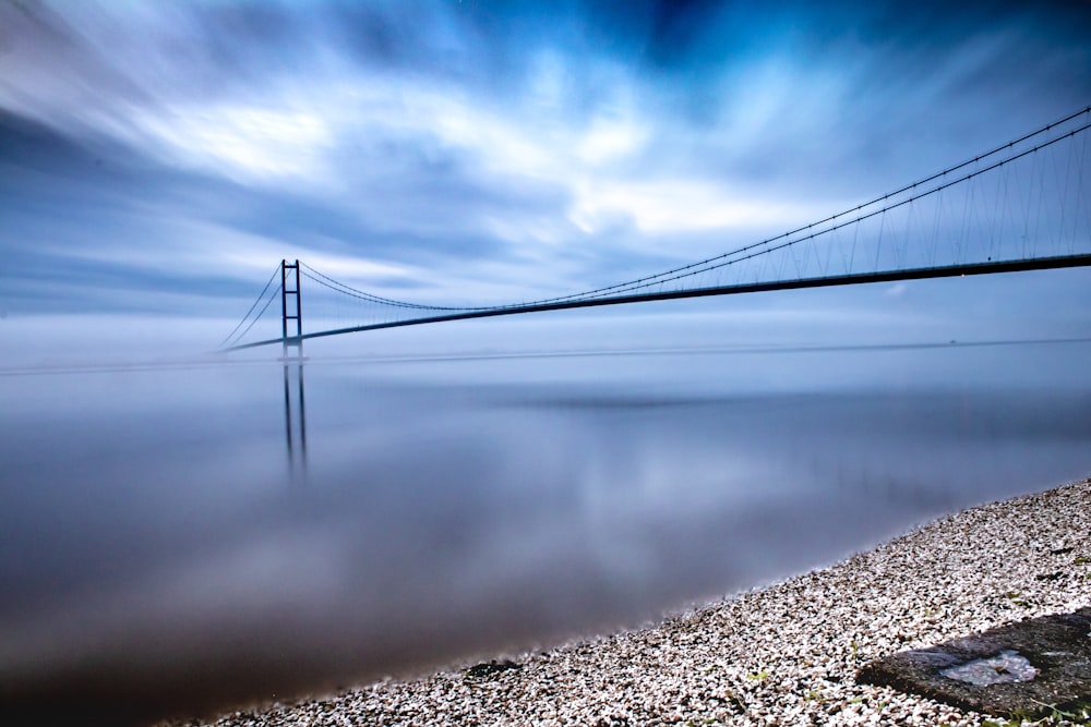 bridge over water under cloudy sky during daytime