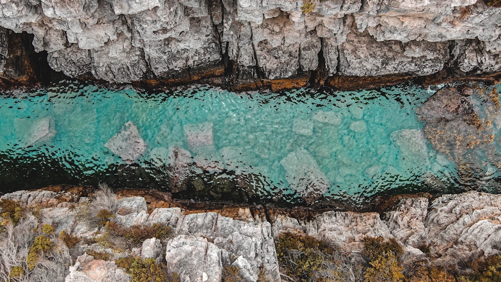 body of water near gray rock