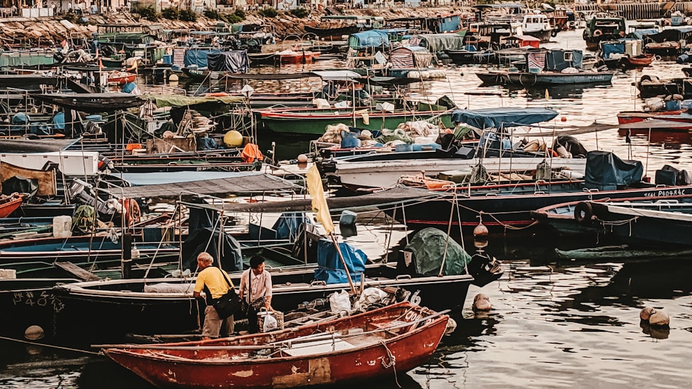 man in yellow shirt sitting on red and white boat during daytime