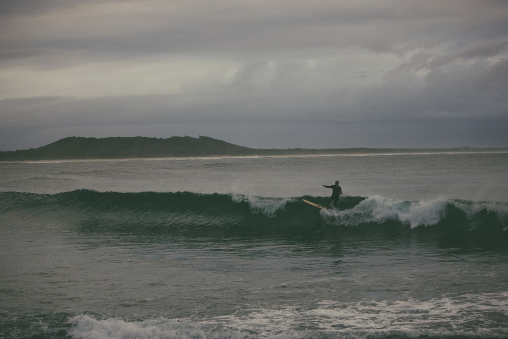 man surfing on sea waves during daytime