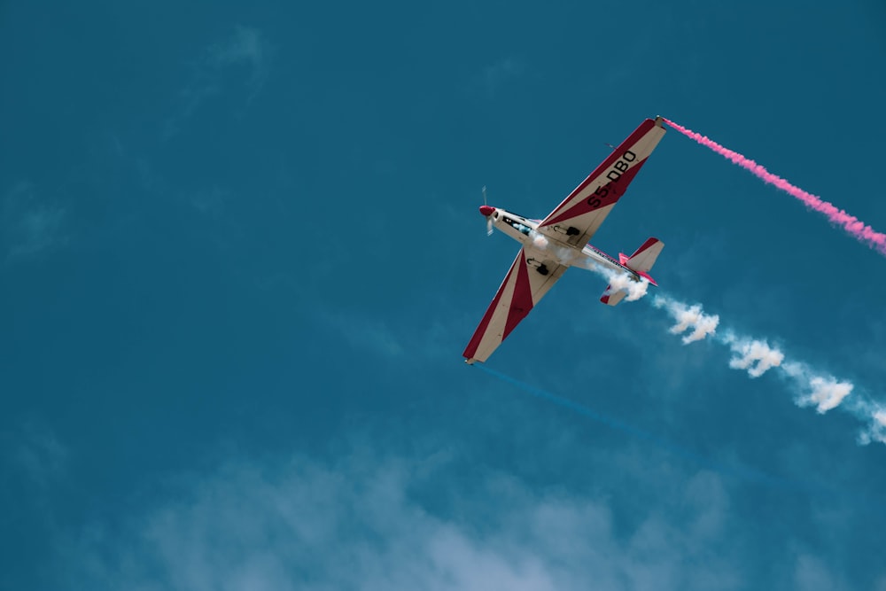 red and white airplane flying in the sky