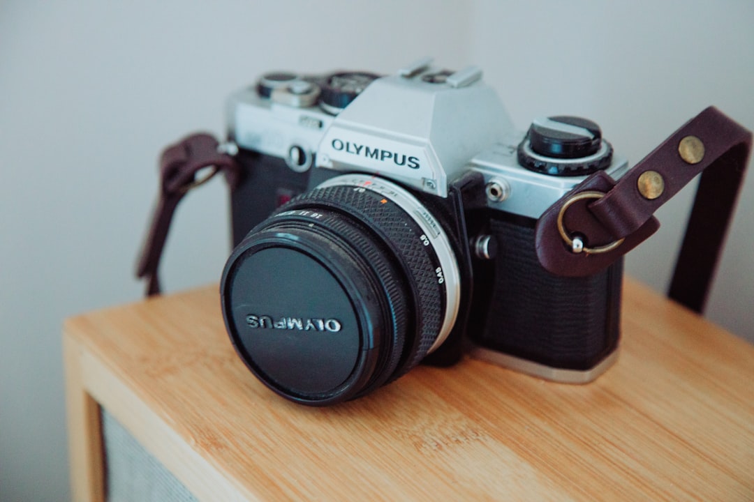 black and gray nikon dslr camera on brown wooden table