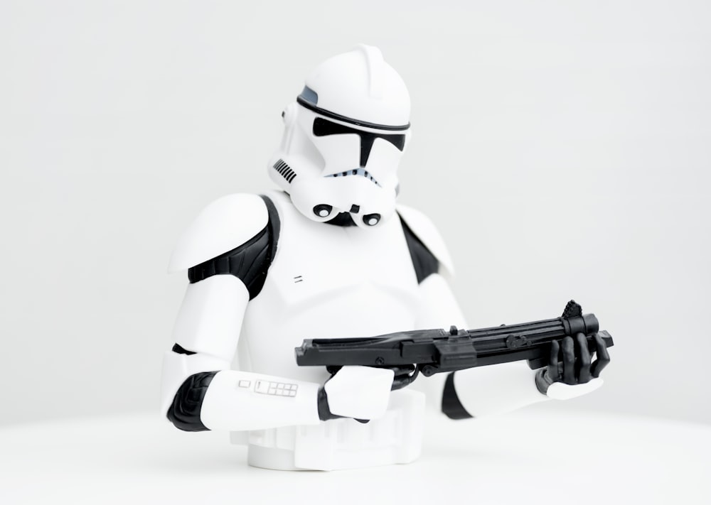 white robot holding black airsoft rifle