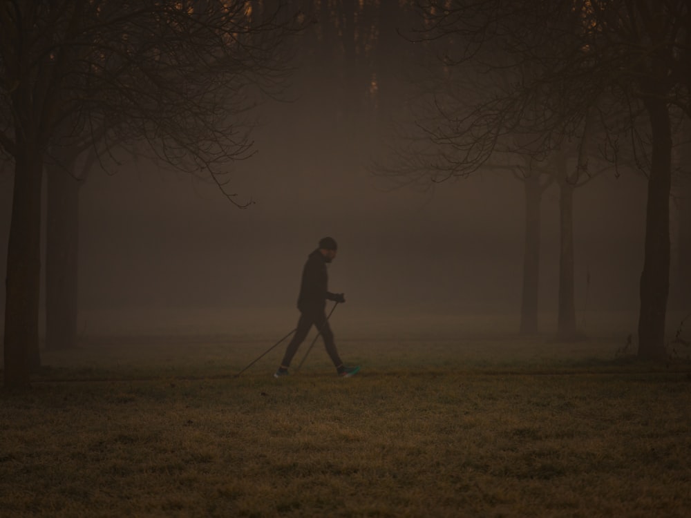 Silhouette eines Mannes, der bei Sonnenuntergang auf einem Rasenplatz steht