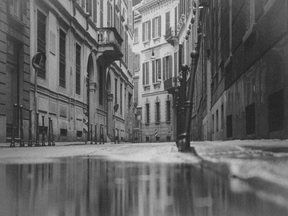 grayscale photo of a street in between buildings