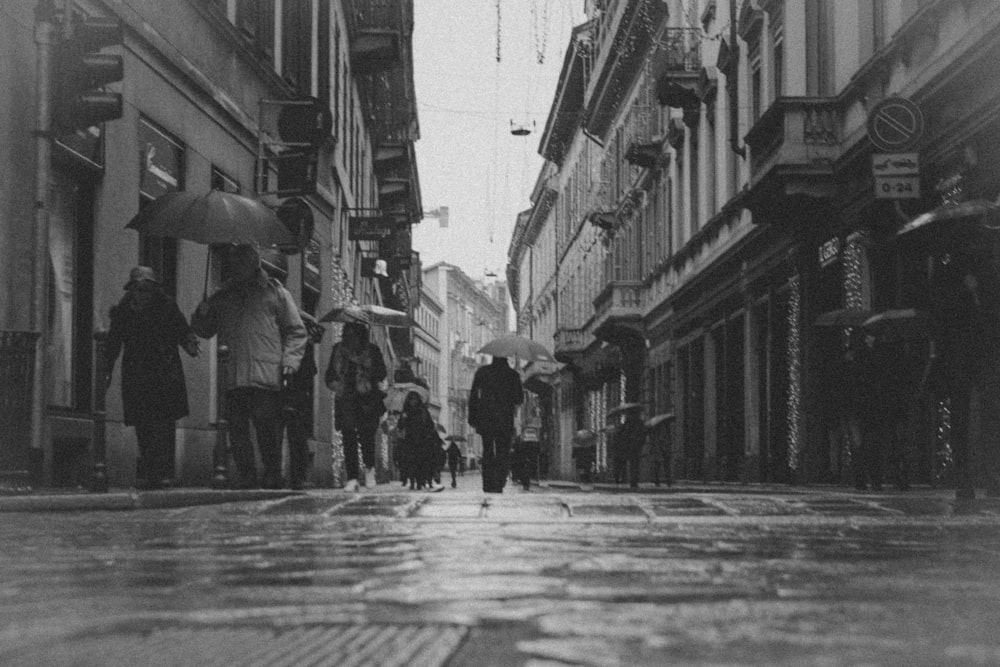 people walking on street in grayscale photography