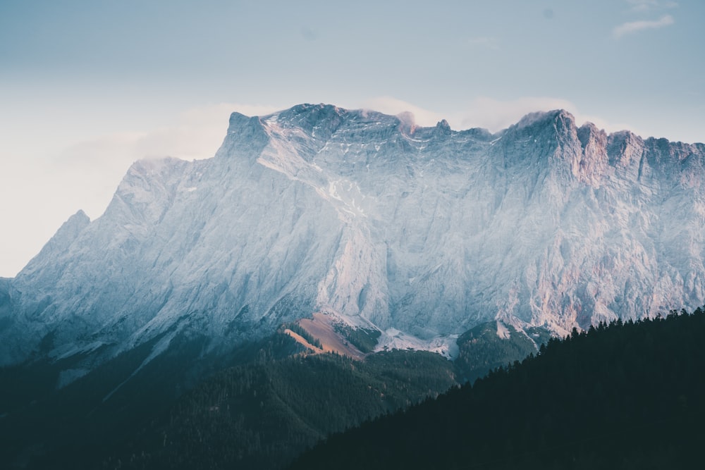 snow covered mountain under cloudy sky during daytime