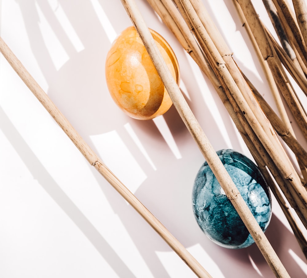 blue and brown ball on brown wooden sticks